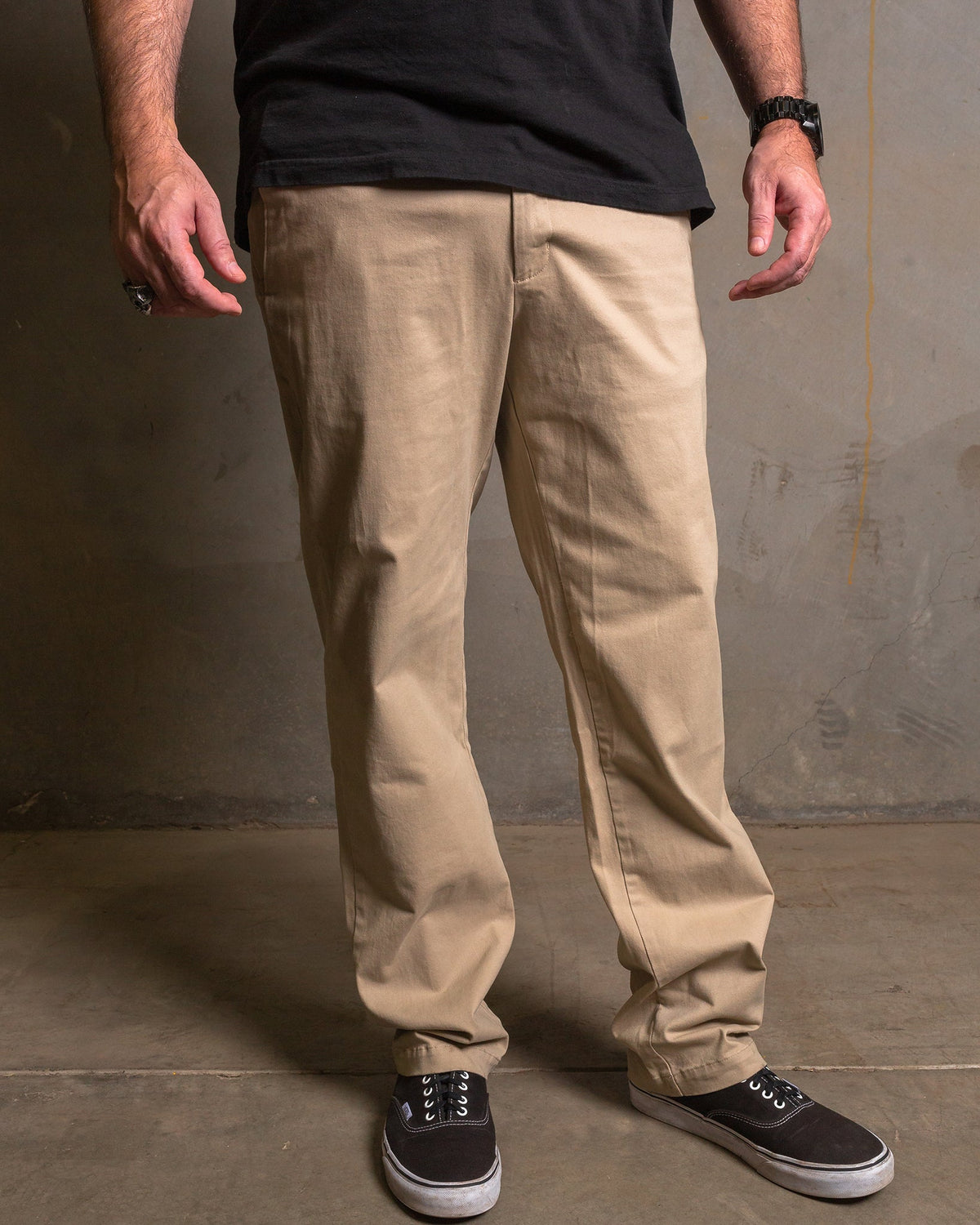 Dixxon Canada. Khaki Chino Pants. Model wearing slim-fit, straight-leg chino pants with a clean front design and dual front slash pockets.